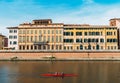 Rowers on River Arno in Pisa, Tuscany, Italy with stunning colourful Italian architecture in the background