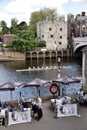 Rowers on The River Ouse, with pub customers looking on. York, UK. May 25, 2023.