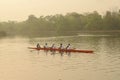 Rowers rowing a long boat in the morning at rabindra sarobar lake at kolkata