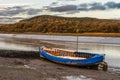 A rowing boat lies on the mud waiting for the tide to return Royalty Free Stock Photo