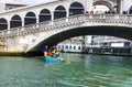 Rowing boat team under Rialto Bridge in Venice Royalty Free Stock Photo