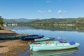 Rowing boats for hire for pleasure and leisure by beautiful lake and mountains on calm still day Royalty Free Stock Photo