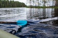 Rowing oar with a wooden handle and a plastic blade, against the backdrop of a lake and forest. View from an inflatable Royalty Free Stock Photo