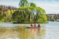 rowing a rowboat and having fun in city park. People in row boat ride on lake Royalty Free Stock Photo