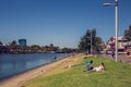 Two people lay down on the bank of Yarra River. 4PM, 25 February, 2017 Royalty Free Stock Photo