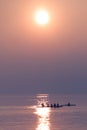 Rowing Team Training with Trainer over Shimmering Lake at Sunset Royalty Free Stock Photo