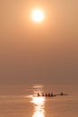 Rowing Team Training with Trainer over Shimmering Lake at Sunset Royalty Free Stock Photo