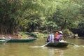 Rowing woman row a boat with tourist on the river with woods in the background at Trang An Grottoes in Ninh Binh, Vietnam