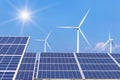 Rows array of polycrystalline silicon solar panels and wind turbines generating electricity in hybrid power plant systems station Royalty Free Stock Photo