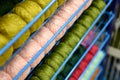 Rows of balls of colorful cotton yarn threads for knitting pale pink and green colors on the shelves in the store. Royalty Free Stock Photo