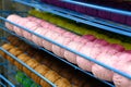 rows of balls of colorful cotton yarn threads for knitting pale pink and mustard colors on the shelves in the store. Royalty Free Stock Photo