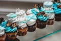 Rows of birthday cupcake with butter white and blue cream icing on a glass stand