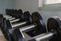 Rows of black dumbbell set on rack in the gym. Health care concept