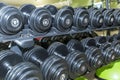Rows of black dumbbells of different weights in the gym. Sport, activity and health. Close-up Royalty Free Stock Photo