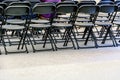 Rows of black folding chairs empty