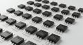 Rows of black semiconductor devices, likely MOSFETs, are arranged neatly on a white Royalty Free Stock Photo