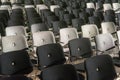 Rows of black and white chairs in the conference room with a brown floor. Royalty Free Stock Photo