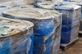 Rows of Blue Plastic Drums Covered in Plastic Wrap Awaiting Disposal or Recycling Process Royalty Free Stock Photo