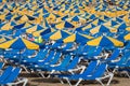 Rows of blue sunbeds with blue and yellow parasols at the beach Playa de Puerto Rico on the Canary Island