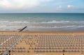 Rows of blue and white parasols and sunbeds on the beach. Italy