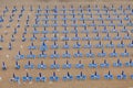 Rows of blue and white parasols and sunbeds on the beach. Italy