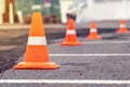 Rows of bright orange traffic cones placed on the asphalt road at a construction site road repairs Royalty Free Stock Photo