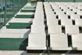 Rows of broken and stained white chairs an outdoor auditorium