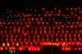 Rows of burning church candles on a black background