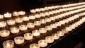 Rows of burning lit candles / tealights in Catholic Christian Church Royalty Free Stock Photo