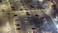 Rows of cars parked in a parking lot between lines viewed from above night timelapse Royalty Free Stock Photo