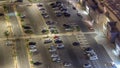 Rows of cars parked in a parking lot between lines viewed from above night timelapse Royalty Free Stock Photo