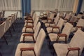 Rows of chairs made of metal and brown velour upholstery are empty in the building Royalty Free Stock Photo