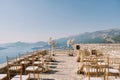 Rows of chairs stand in front of a wedding semi-arch on an observation deck over the sea
