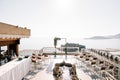 Rows of chairs stand on the terrace of a restaurant with a fountain above the island of Sveti Stefan. Montenegro Royalty Free Stock Photo