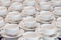 Rows of clean white coffee or tea cups, dish and spoon in a cafeteria or restaurant ready to serve a hot beverage Royalty Free Stock Photo