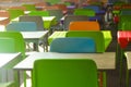 Rows of colored plastic empty tables and chairs