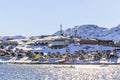 Rows of colorful Inuit houses along the fjord with snow mountain Royalty Free Stock Photo