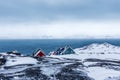 Rows of colorful inuit houses hiding in the rocks with fjord in Royalty Free Stock Photo