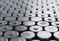 Rows of cylindrical batteries with metallic tops, each featuring a small, raised positive terminal. Royalty Free Stock Photo