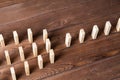 Rows of dominoes standing on wooden table