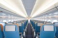 rows of empty airplane seats with overhead compartments