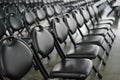 Rows of empty black folding chairs Royalty Free Stock Photo