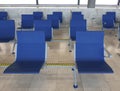Rows of empty blue seats in airport terminal. Contemporary lounge with seats in the airport, blue tone. Bench in the terminal of Royalty Free Stock Photo
