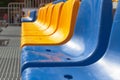 Rows of empty blue and yellow plastic chairs in bright sunlight. Urban architecture Royalty Free Stock Photo