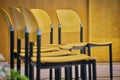 Rows of empty chairs prepared for an indoor event. Chairs made of light brown wood with black metal structure Royalty Free Stock Photo