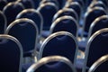 Rows of empty metal chairs in a large assembly hall.Empty chairs in conference hall.Interior meeting room. Back view