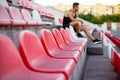 Rows of empty seats in a sport stadium, young sportsman on background Royalty Free Stock Photo