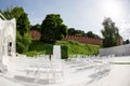 Rows of empty white chairs sitting on a wooden floor. Wedding chairs with flowers at ceremony outdoors Royalty Free Stock Photo