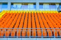 Rows of empty yellow and orange plastic seats in a stadium Royalty Free Stock Photo