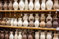 rows of finished stoneware vases on a display shelf